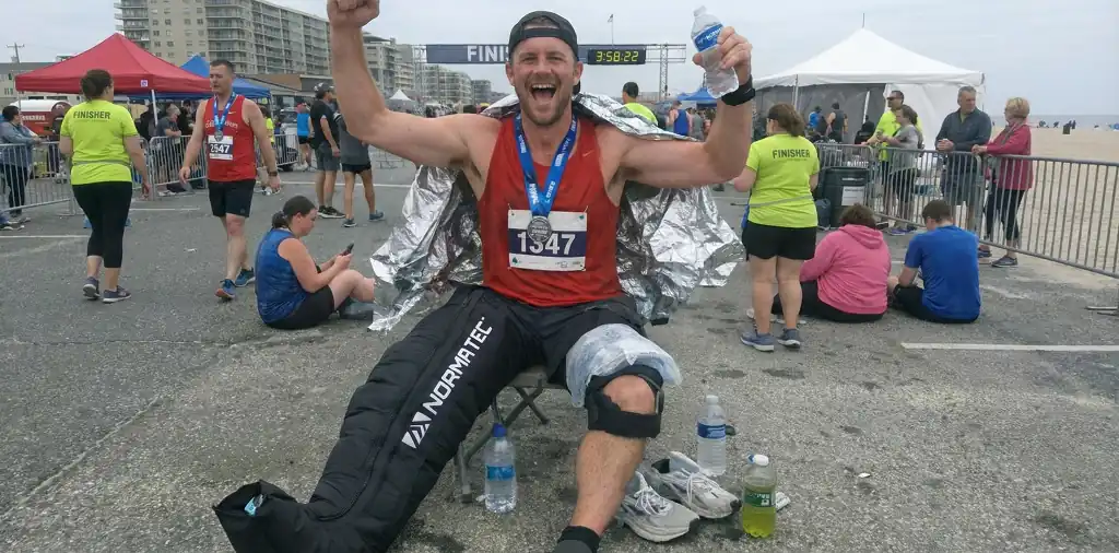 Runner celebrating marathon finish, needing marathon recovery gear