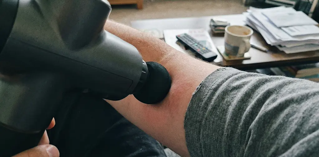 Percussive therapy device applying pressure to muscle